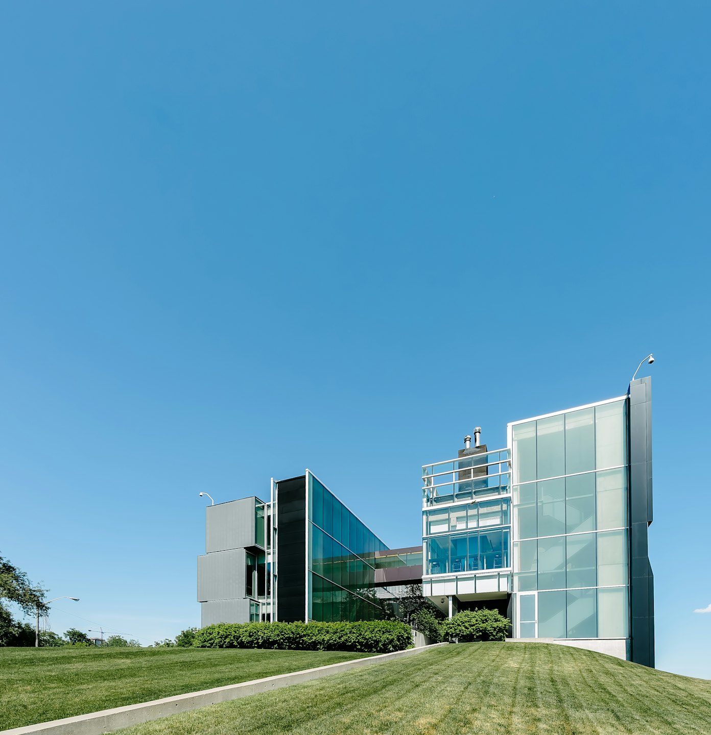 Modern glass and grey office building with geometric design.