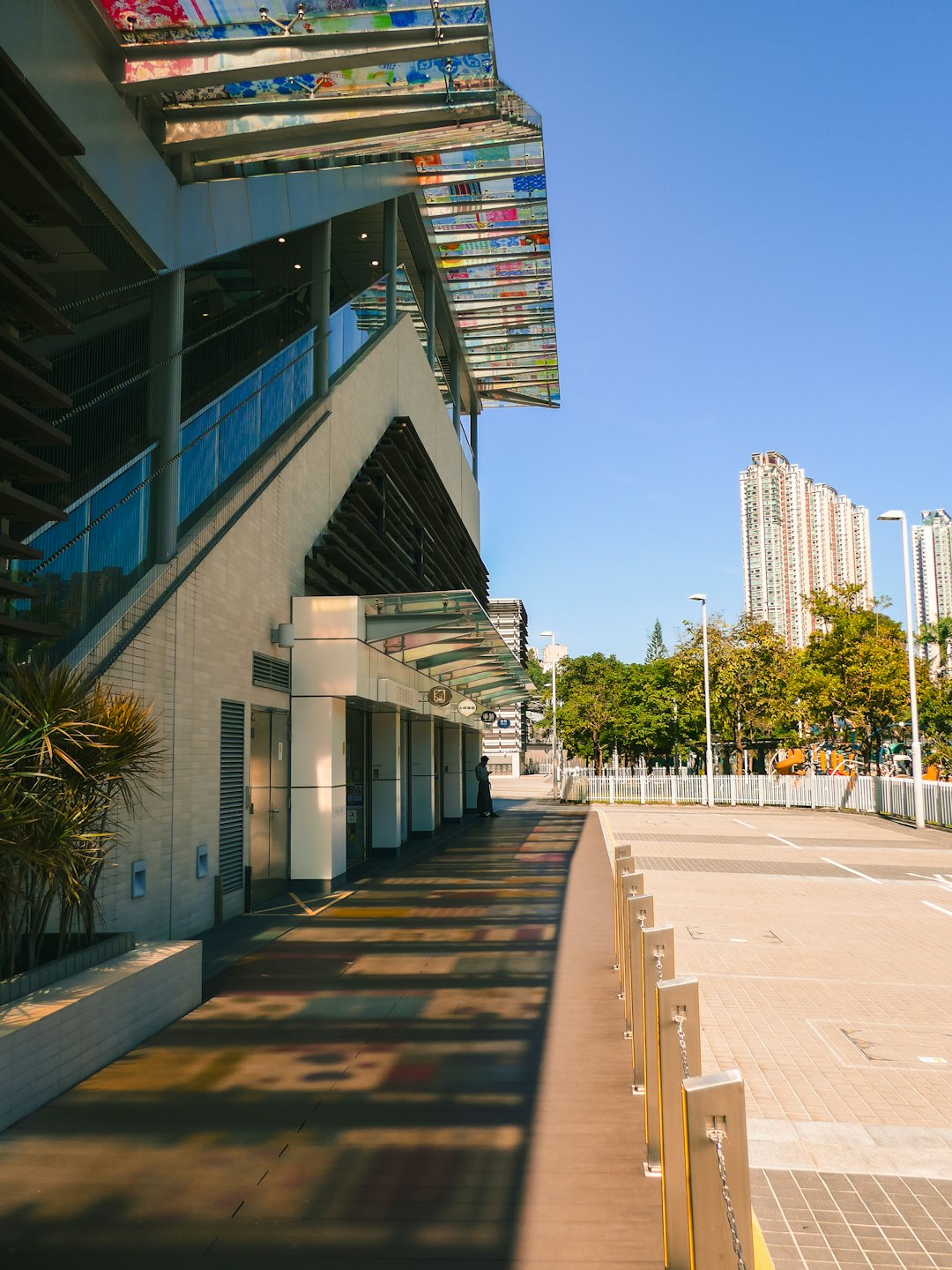 Person standing outside a modern brick and glass office building.